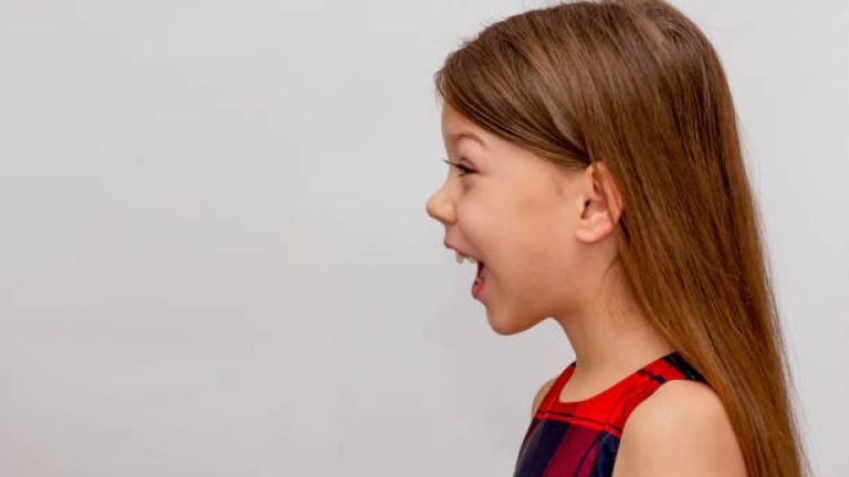 Profile of child with open mouth on white background