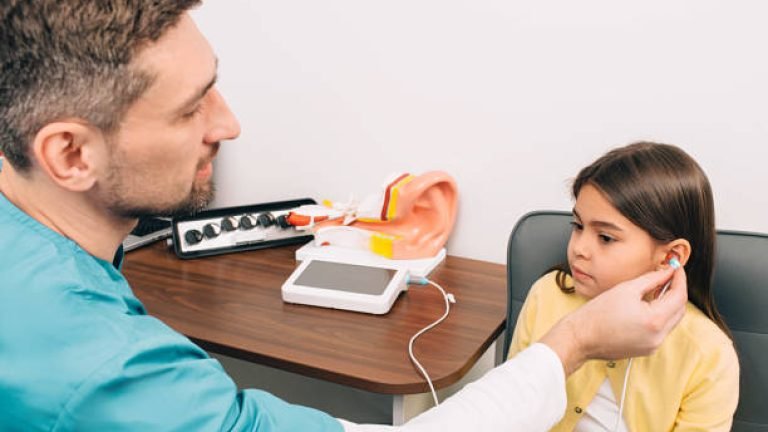 Audiologist check a child's ears.Mixed race girl having hearing test , procedure impedance audiometry