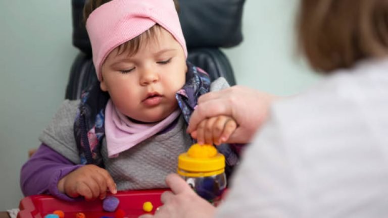 A psychologist works with a small child with mental retardation.